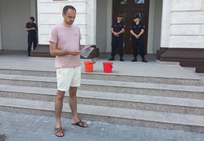 FOTO. Andrei Donică a început un protest permanent în faţa Procuraturii. Îl aşteaptă pe Harunjen cu două găleţi cu lapte